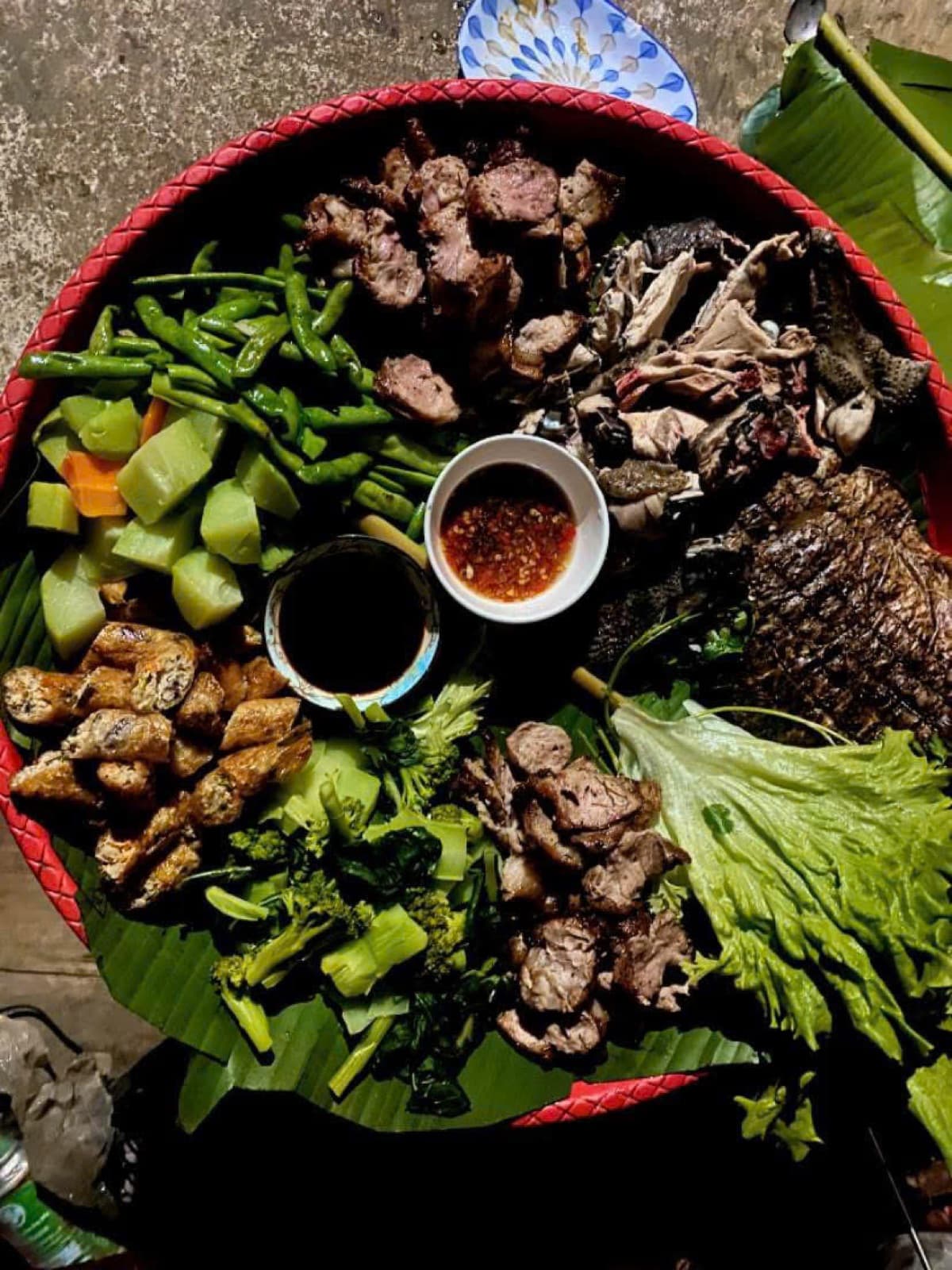Grilled meats, fish and vegetables served on banana leaves