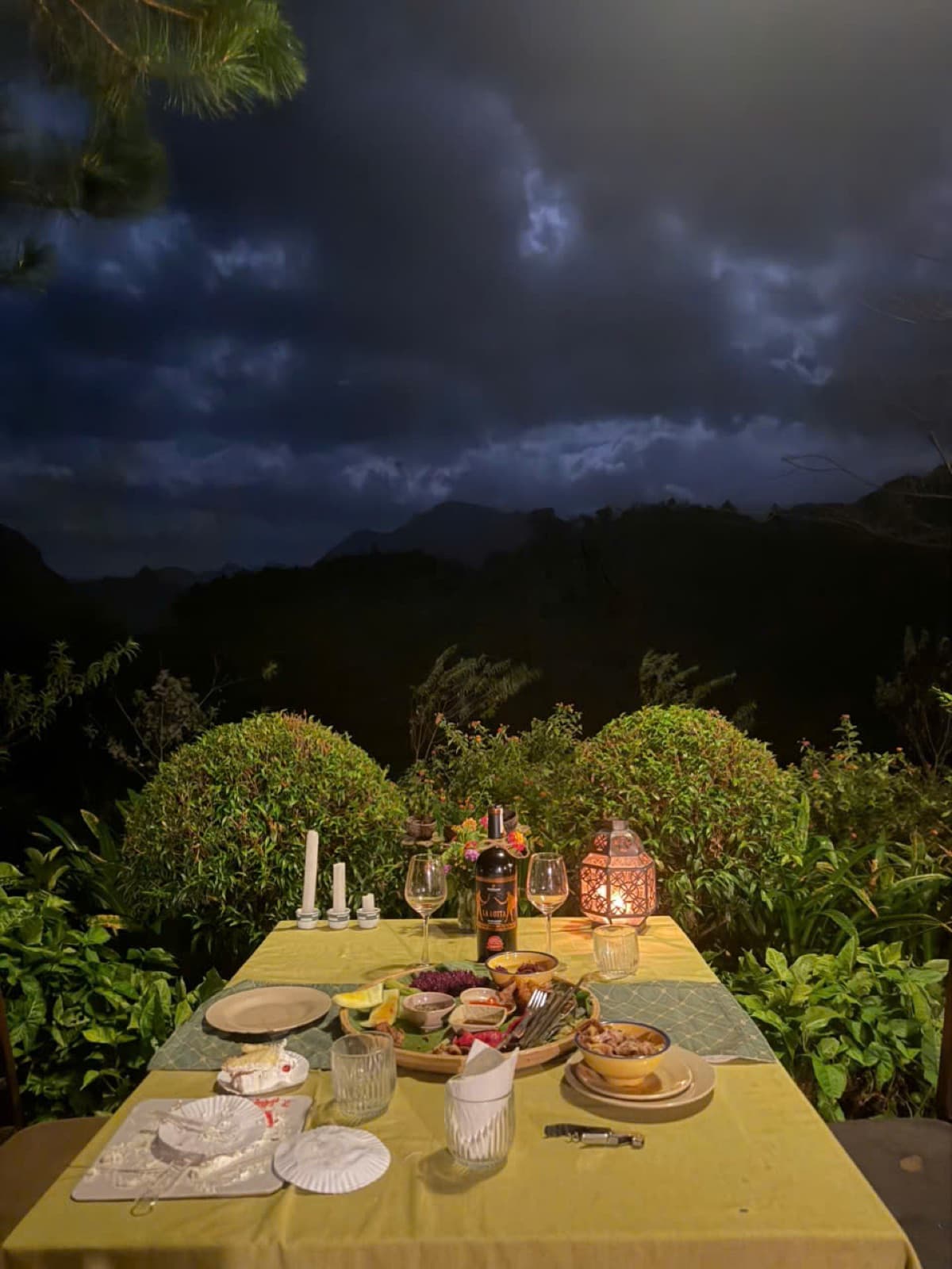 A candlelit dinner table facing the mountains at dusk